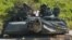 Dua tentara AS di atas tank M1 Abrams melakukan pergerakan kendaraan sebagai bagian dari pelatihan bagi pasukan Ukraina di Area Pelatihan Hohenfels, Jerman, 2 Juni 2022.