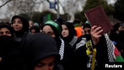 A woman holds a copy of the Quran during a protest in Istanbul, Turkey, Jan. 29, 2023, following the burning of the Quran in Stockholm.