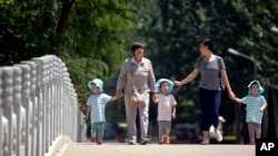 资料照片：两名中国妇女带着孩童走在北京街头。(2017年6月1日)