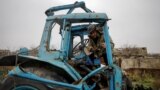 (FILE) Local farmer in Ukraine inspects his tractor that was damaged in Russia's attacks.