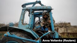 (FILE) Local farmer in Ukraine inspects his tractor that was damaged in Russia's attacks.