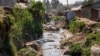 A tributary full of garbage, which feeds into the Nairobi River, flows through the informal settlement of Kibera in Nairobi, Kenya, Wednesday, Jan. 11, 2023. (AP Photo/Khalil Senosi)