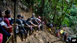 ARCHIVO - Migrantes, en su mayoría venezolanos, cruzan el Tapón del Darién desde Colombia hacia Panamá, con la esperanza de llegar a Estados Unidos, el 15 de octubre de 2022.