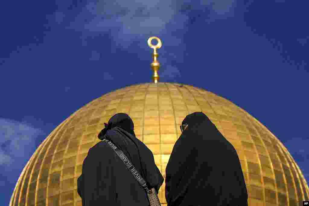 Women sit by the Dome of the Rock Mosque at the Al-Aqsa Mosque compound in the Old City of Jerusalem.