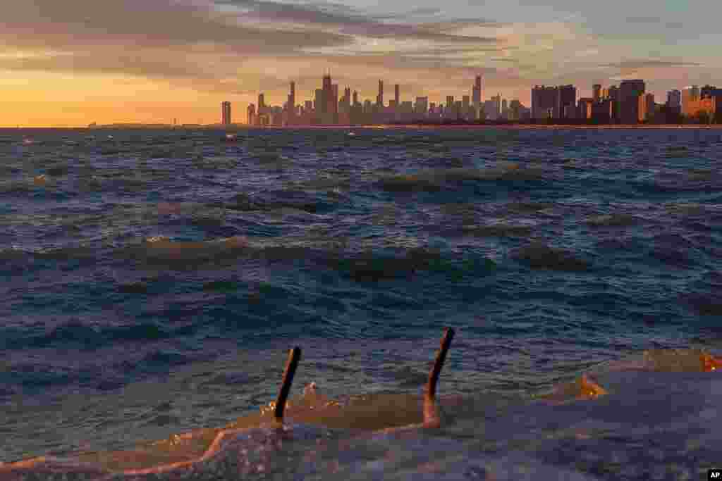 The sun rises over a choppy Lake Michigan as seen from Montrose Harbor, in Chicago.