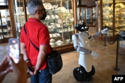 Robot humanoid R1, dirancang oleh Institut Teknologi Italia, berfungsi sebagai panduan virtual bagi pengunjung. (Foto: AFP)