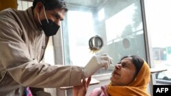 A health worker collects a nasal swab sample from a woman to test for COVID-19 at a hospital in Amritsar on Jan. 5, 2023.