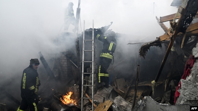 Ukrainian firefighters work in a house in flame following Russian shelling in the city of Kherson, on Jan. 29, 2023, amid the Russian military invasion of Ukraine.