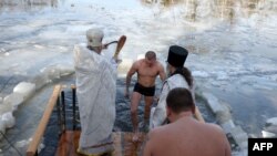 Priests bless the water as servicemen bathe in the icy Siverskyi Donets River next to the Sviatohirsk Orthodox Christian Monastery during the Orthodox Epiphany celebration in the town of Svyatohirsk, Donetsk region, Ukraine, on Jan. 19, 2023.