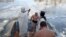 Priests bless the water as servicemen bathe in the icy Siverskyi Donets River next to the Sviatohirsk Orthodox Christian Monastery during the Orthodox Epiphany celebration in the town of Svyatohirsk, Donetsk region, Ukraine, on Jan. 19, 2023.