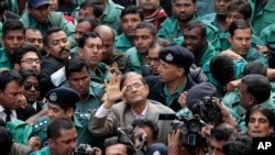 Mirza Fakhrul Islam Alamgir, tengah, penjabat sekretaris jenderal oposisi Partai Nasionalis Bangladesh, melambaikan tangannya kepada para pendukungnya saat ia dikawal oleh polisi ke pengadilan di Dhaka, Bangladesh, Rabu, 7 Januari 2015. (Foto: AP)