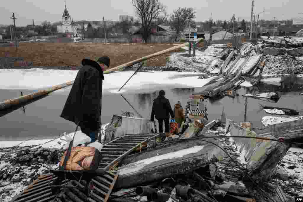 People cross a destroyed bridge in Bakhmut, amid the Russian invasion of Ukraine.