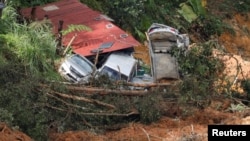 Damaged cars are seen amongst the debris during a rescue and evacuation operation following a landslide at a campsite in Batang Kali, Selangor, Malaysia, Dec. 17, 2022.