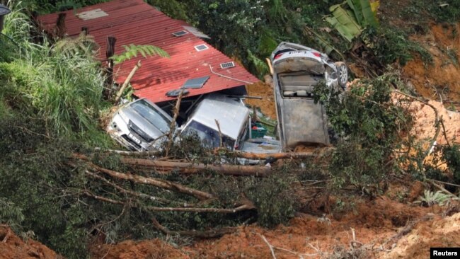 Damaged cars are seen amongst the debris during a rescue and evacuation operation following a landslide at a campsite in Batang Kali, Selangor, Malaysia, Dec. 17, 2022.