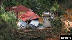 Sejumlah kendaraan dan reruntuhan bangunan terlihat di lokasi longsor di area perkemahan di Batang Kali, Selangor, Malaysia, pada 17 Desember 2022. (Foto: Reuters/Hasnoor Hussain)