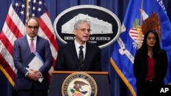 El secretario de Justicia de EEUU, Merrick Garland, acompañado por los fiscales generales adjuntos Vanita Gupta y Jonathan Kanter, de la División Antimonopolio del Departamento de Justicia, habla en el Departamento de Justicia en Washington, el martes 24 de enero de 2023.