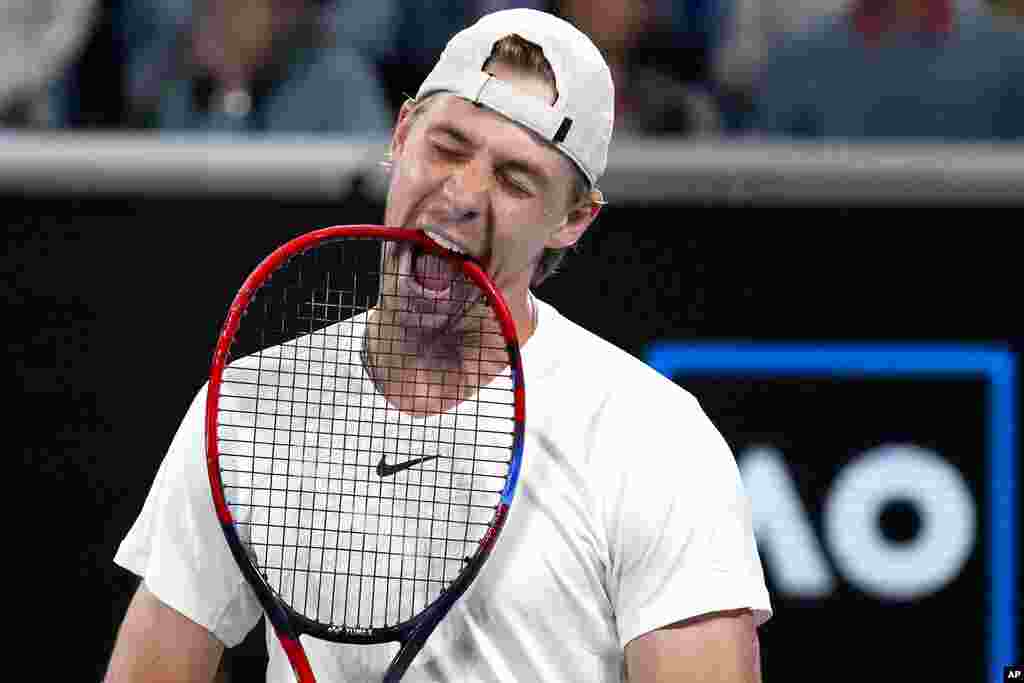 Denis Shapovalov of Canada bites on his racket in frustration during his third round match against Hubert Hurkacz of Poland at the Australian Open tennis championship in Melbourne, Australia.