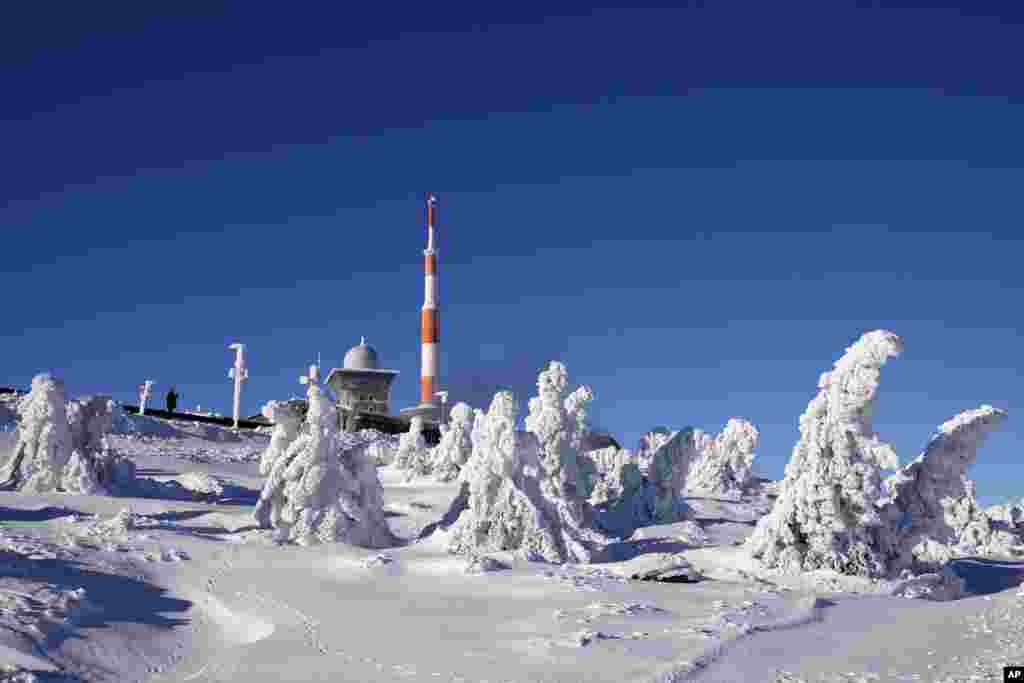 A man takes pictures of snow and ice covered trees at the 1,142-meter high (3,743 feet) Brocken at the Harz mountains near Schierke, Germany.