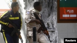 Somali policemen hold their positions near the mayor's office following a blast in Mogadishu, Jan. 22, 2023. 