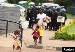 A woman arrives with kids at the magistrate court where 25 opposition party Citizens Coalition for Change supporters appear for a bail hearing after they were arrested for unlawful gathering with intent to incite public violence in Harare, Zimbabwe. REUTERS/Philimon Bulawayo