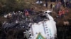Petugas penyelamat memeriksa lokasi di sekitar reruntuhan pesawat wisata yang jatuh di Pokhara, Nepal, Senin, 16 Januari 2023. (AP/Yunish Gurung)