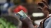 FILE - A person holds notes of the Ghana currency, in Accra, Ghana, Dec. 1, 2022. Ghana is battling its worst economic crisis in decades.