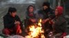 Sekelompok anak laki-laki Afghanistan duduk di dekat api unggun di pinggir jalan Kabul pada musim dingin, 30 Desember 2022. (AFP)