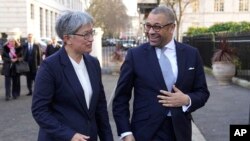 Britain's Foreign Secretary James Cleverly welcomes Australian Minister for Foreign Affairs Penny Wong, left, at Carlton Gardens in London, ahead of their bilateral meeting, Feb. 1, 2023.
