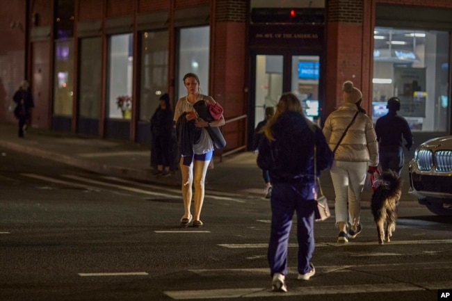 People cross the street on Tuesday, Jan. 17, 2023, in New York. (AP Photo/Andres Kudacki)