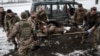 Paramedics carry an injured Ukrainian serviceman who stepped on an anti-personnel land mine at a stabilisation point for emergency treatment before sending him to a hospital near the frontline in the Donetsk region, Jan. 29, 2023.