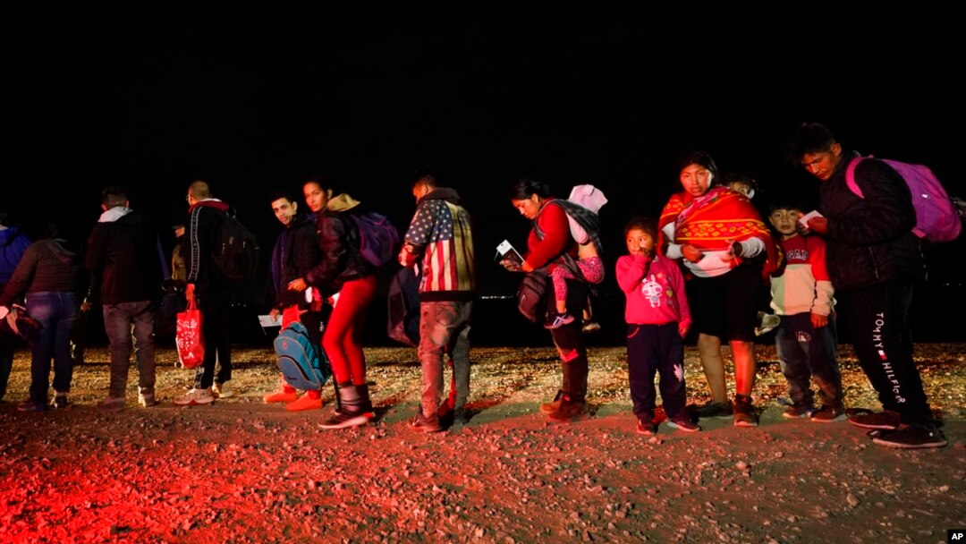 Migrants wait to be processed after crossing the U.S. border. Jan. 6, 2023, near Yuma, Ariz.