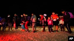 Migrants wait to be processed after crossing the U.S. border. Jan. 6, 2023, near Yuma, Ariz.