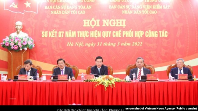 Ông Tô Lâm (thứ hai, bên phải) và ông Võ Văn Thưởng (giữa) tại một hội nghị về tòa án và viện kiểm sát ở Hà Nội, 31/3/2022.