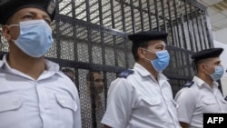 FILE: Police officers stand guard outside the defendant's box, as Egyptian Mohamed Adel, the defendant in the murder of University of Mansoura student Naira Ashraf, attends his first trial session at the Mansoura courthouse, some 145km north of Egypt's capital, on June 26, 2022