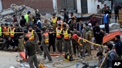 Petugas keamanan dan petugas penyelamat berkumpul di lokasi bom bunuh diri, di Peshawar, Pakistan, Senin, 30 Januari 2023. (Foto: AP)