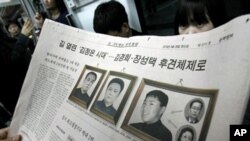 A South Korean newspaper shows photos of North Korean leader Kim Jong Il, center, his late father Kim Il Sung, left, and a photo South Korean media says of Kim's youngest son Kim Jong Un, At right bottom is Kim Jong-il's sister Kim Kyong Hui and top is he