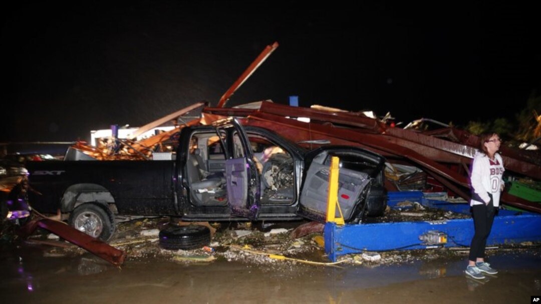 Seorang warga Canton, Texas, memeriksa kerusaksan di dealer mobil Dodge pasca hantaman tornado di kotanya, 29 April 2017.