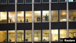 A man looks out a window from an office space during partial lockdown measures amid the coronavirus disease (COVID-19) outbreak in Geneva, Switzerland, November 18, 2020. REUTERS/Denis Balibouse