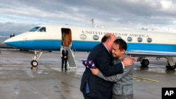 This photo provided by U.S. Embassy Switzerland, Edward McMullen greets Xiyue Wang in Zurich, Switzerland on Saturday, Dec. 7, 2019. 