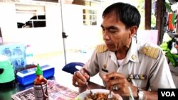 Si Racha municipal government officer and art director Booncherd Nilsonthi glances at a bottle of American-made "Sriracha sauce." (Z. Aung/VOA)