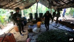 Policías antinarcóticos colombianos inspeccionan un laboratorio de elaborción de cocaína en la selva colombiana. La estrategia conjunta de Colombia Estados Unidos buscará reducir el cultivo de coca y la producción de la droga, para llevarla a la mitad para el año 2023. 