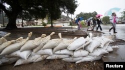 Residents walk past sandbags as rain begins to fall in Glendora, California, Dec. 2, 2014.