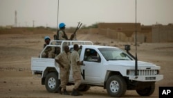 FILE - United Nations peacekeepers stand guard at a polling station, during presidential elections in Kidal, Mali, July 28, 2013.