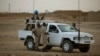 FILE - In this July 28, 2013 photo, United Nations peacekeepers stand guard at a polling station, during presidential elections in Kidal, Mali.