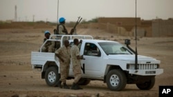 FILE - In this July 28, 2013 photo, United Nations peacekeepers stand guard at a polling station, during presidential elections in Kidal, Mali.