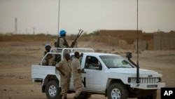 FILE - In this July 28, 2013 photo, United Nations peacekeepers stand guard at a polling station, during presidential elections in Kidal, Mali.