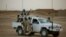 FILE - United Nations peacekeepers stand guard at a polling station, during presidential elections in Kidal, Mali, July 28, 2013.