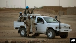 FILE - In this July 28, 2013 photo, United Nations peacekeepers stand guard at a polling station, during presidential elections in Kidal, Mali.