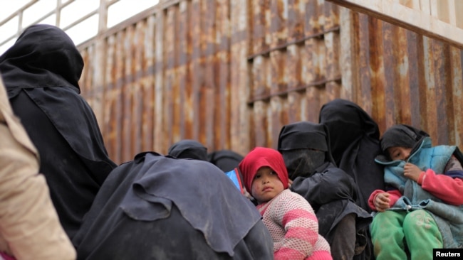 Children sit on the back of a truck near the village of Baghuz, Deir el-Zour province, in Syria, March 7, 2019.