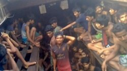 This video grab taken on December 4, 2020 from an AFPTV video shows a Burmese smuggler (C) along with Rohingya refugees in a boat in Chakmarkul on August 26, 2020. - As scores die on a ship packed with desperate Rohingya, Burmese smugglers mercilessly bea